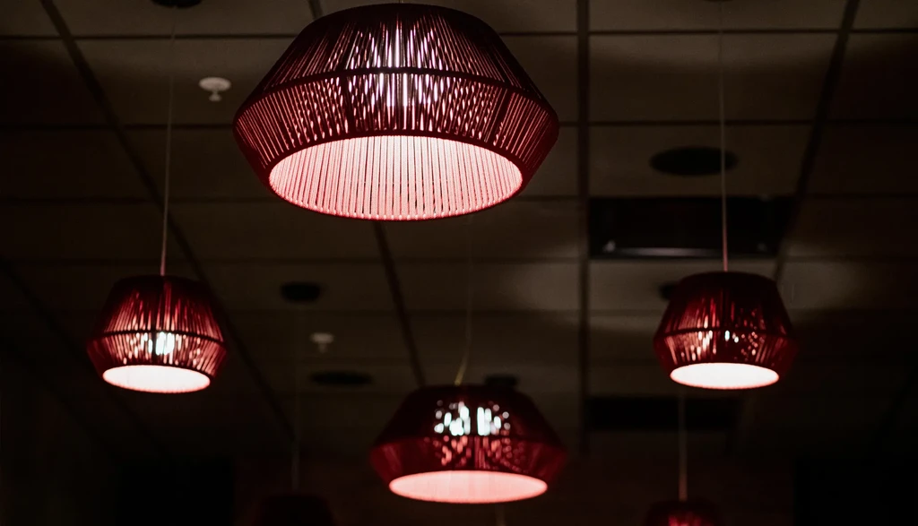 Four woven pendant lights with a warm, reddish glow.