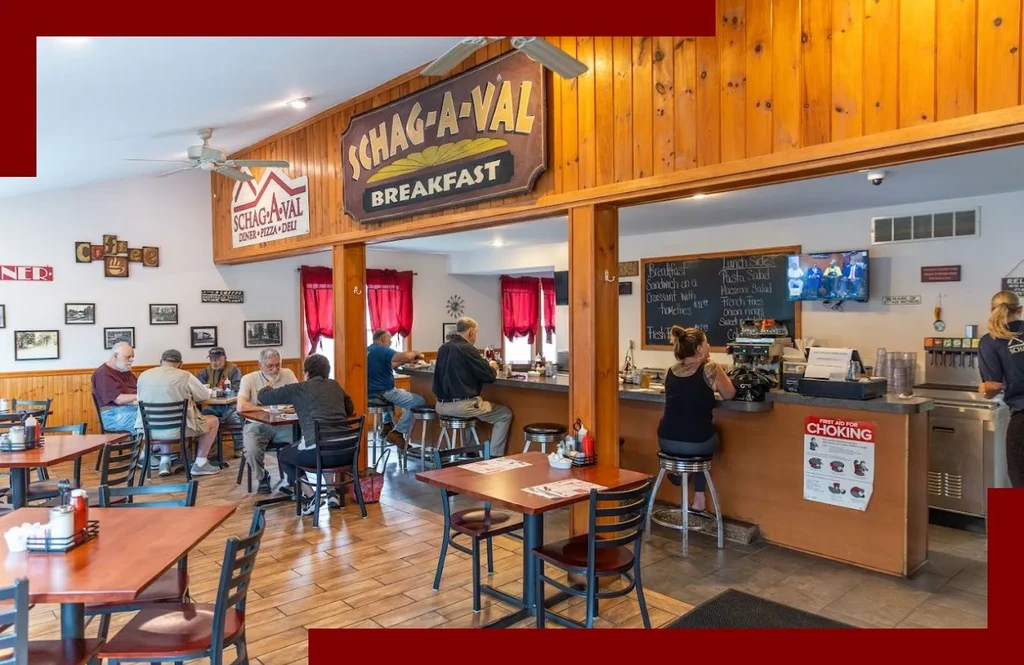 Schag-a-val Diner interior, with customers, empty tables, and a counter.