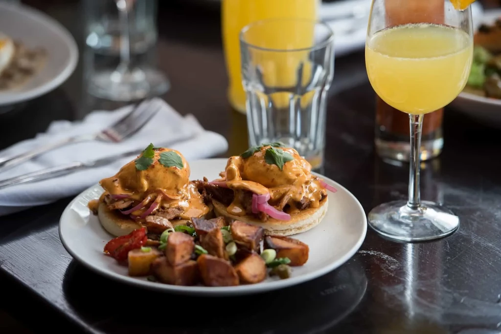Two eggs Benedict, roasted potatoes, and a mimosa for brunch.