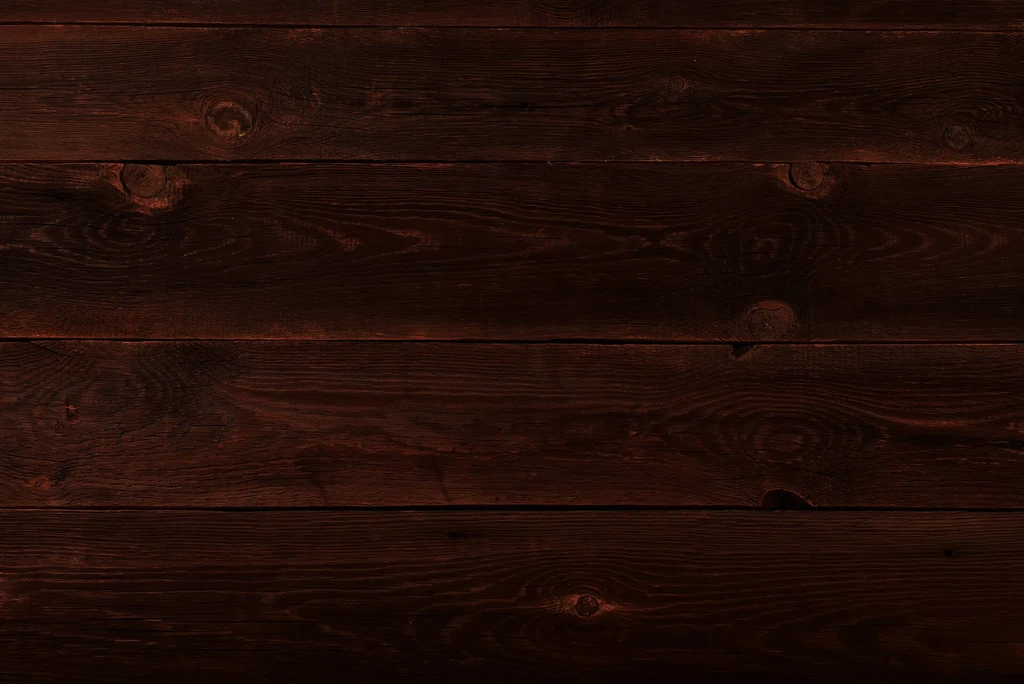 Close-up of dark reddish-brown wooden planks with distinct grain and knots.