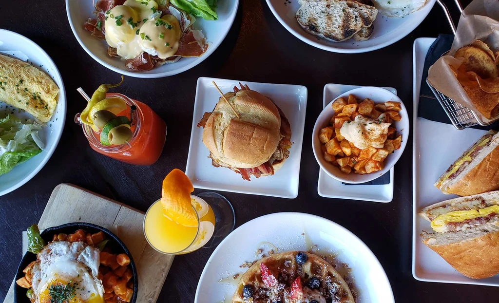 Overhead view of a table with diverse breakfast and brunch dishes.