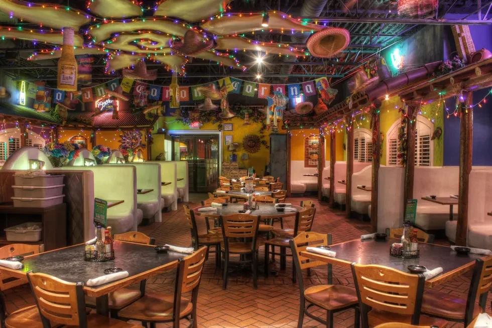 Vibrant Mexican restaurant interior with sombreros, Corona decor, and string lights.