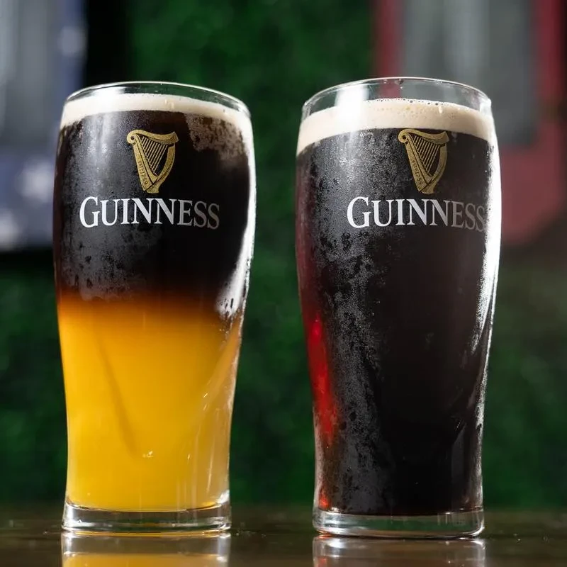 Two cold Guinness beers, one layered Black and Tan.