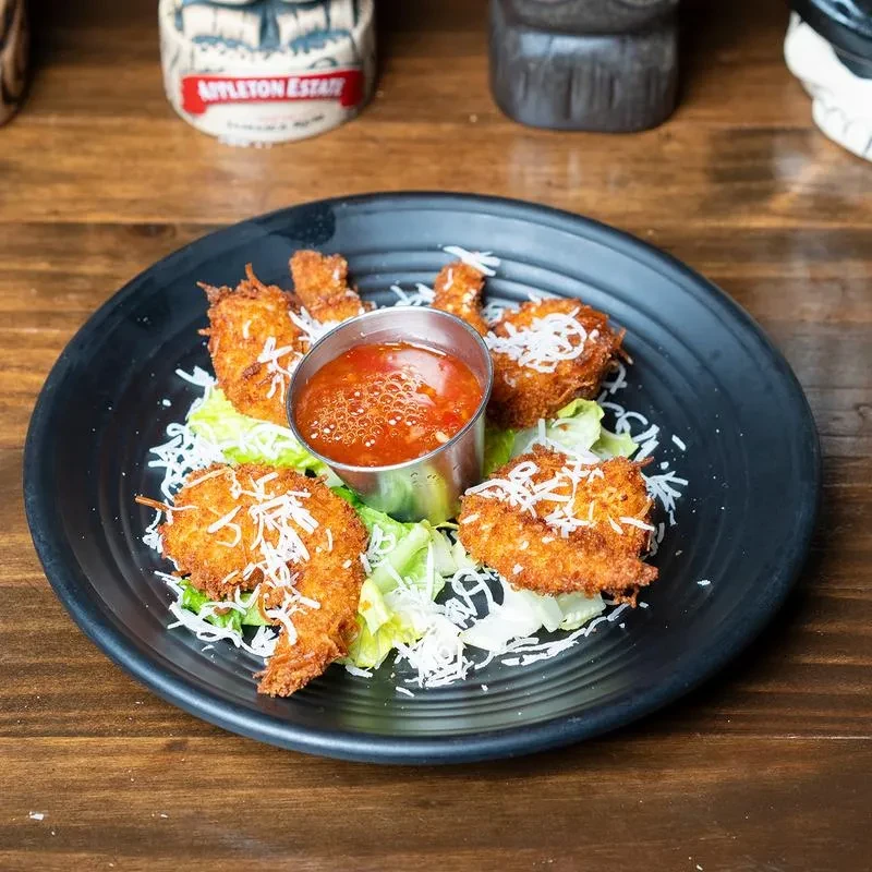 Five crispy fried shrimp with dipping sauce, lettuce, and grated cheese.
