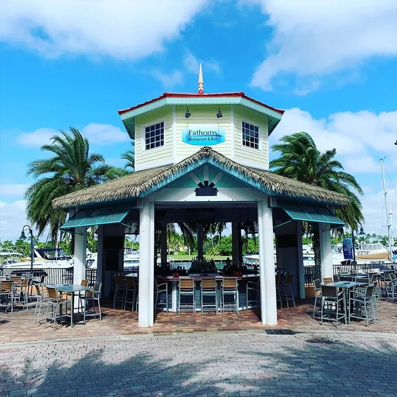 Octagonal tropical Fathoms Restaurant, thatched roof, open bar, by marina.