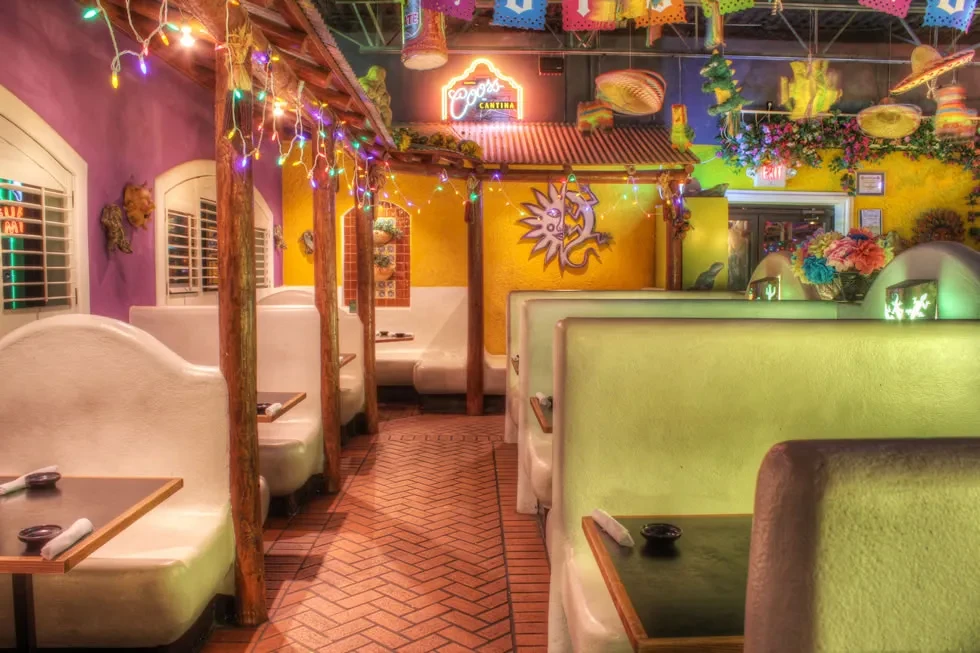 Vibrant, empty Mexican restaurant interior with booths and 'Coors Cantina' sign.
