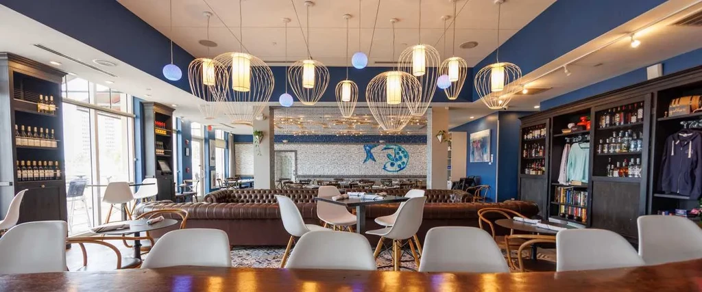 Modern blue and white restaurant interior with a mosaic fish wall.