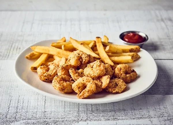 Crispy fried shrimp, golden french fries, and ketchup on a white plate.