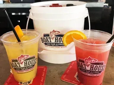 Colorful yellow and red drinks with orange slices and Boat House logos.