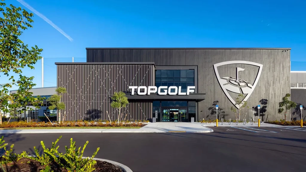 Modern Topgolf building exterior with dark gray panels and prominent white sign.