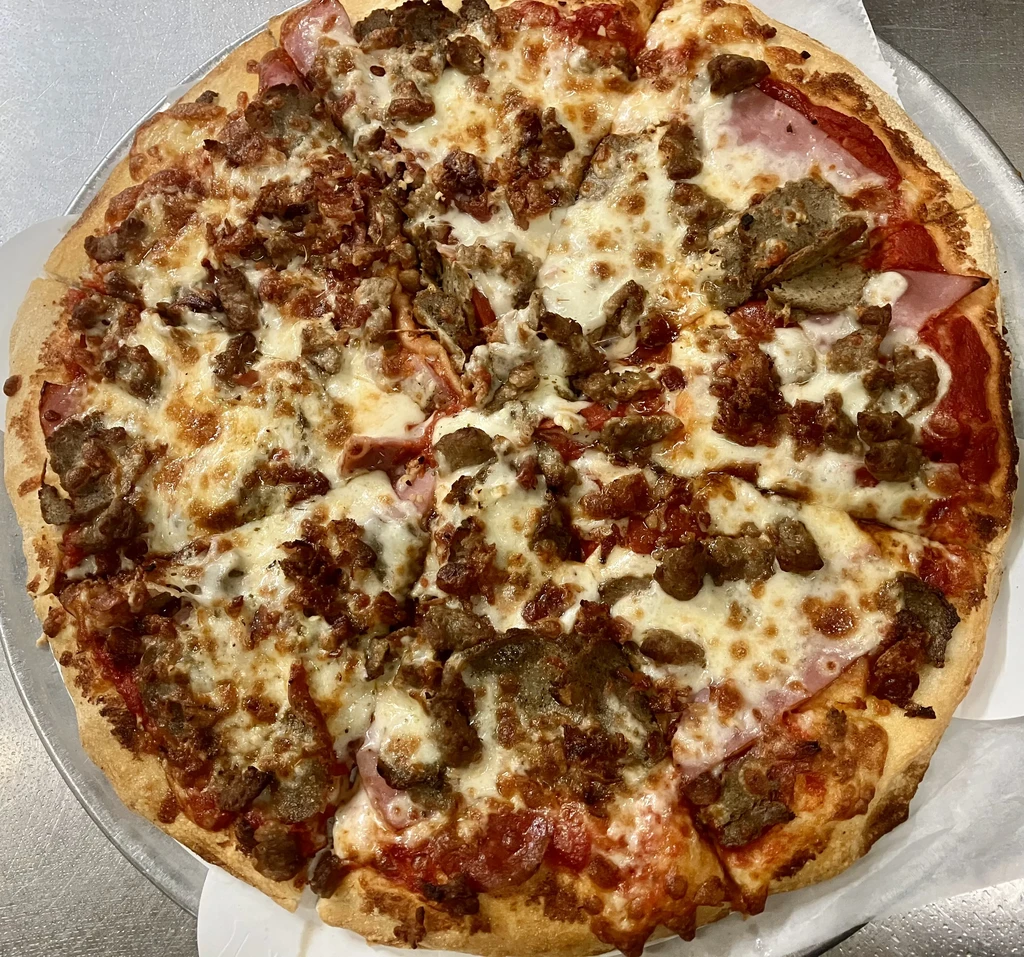 Sliced, baked pizza with crumbled sausage, pepperoni, and melted mozzarella.