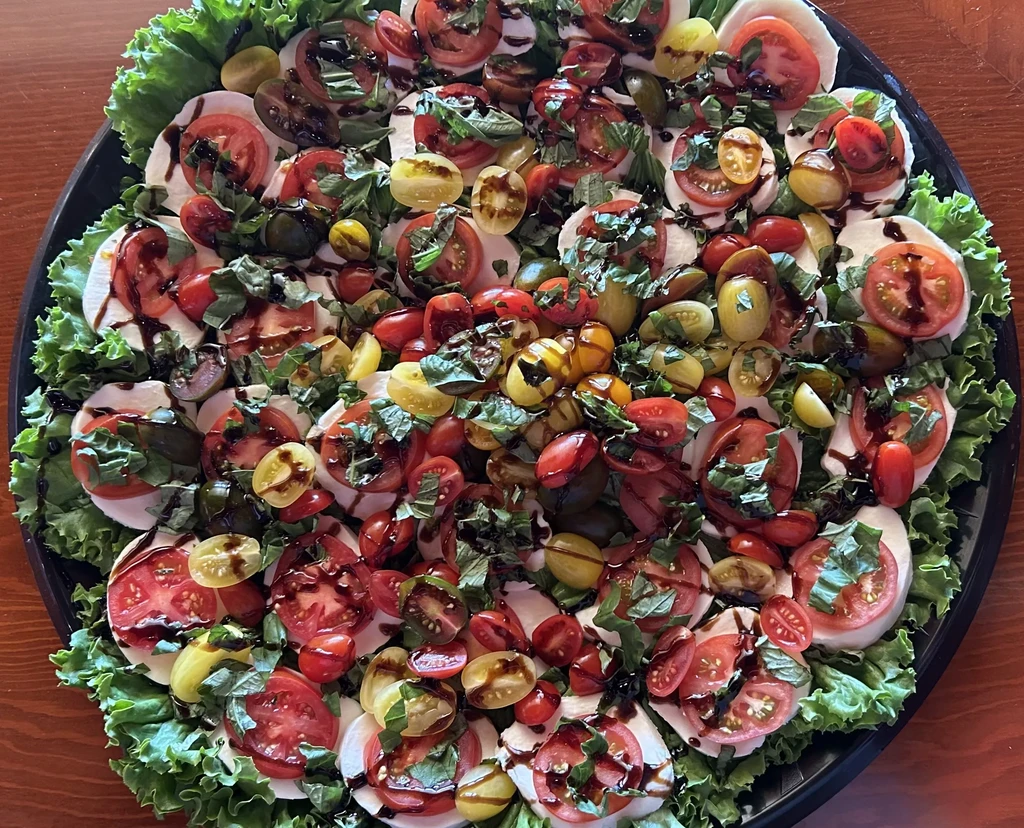 Vibrant Caprese salad with mozzarella, colorful tomatoes, basil, balsamic glaze.