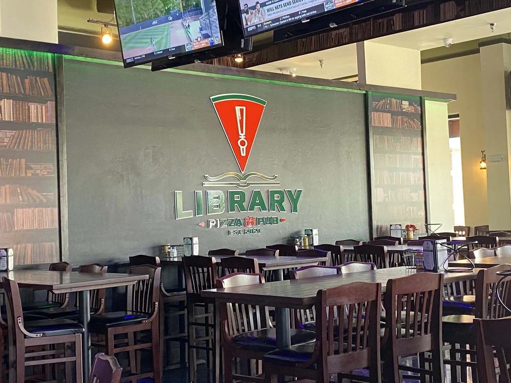 Empty Library Pizza & Pub interior, book decor, and sports TVs.