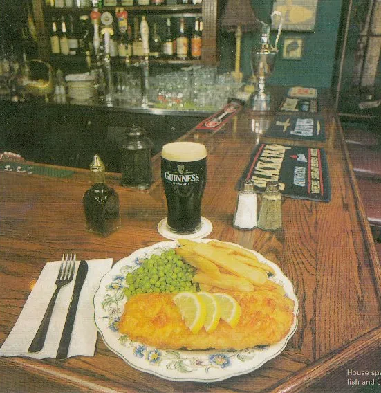 Classic fish and chips with Guinness on a pub bar.