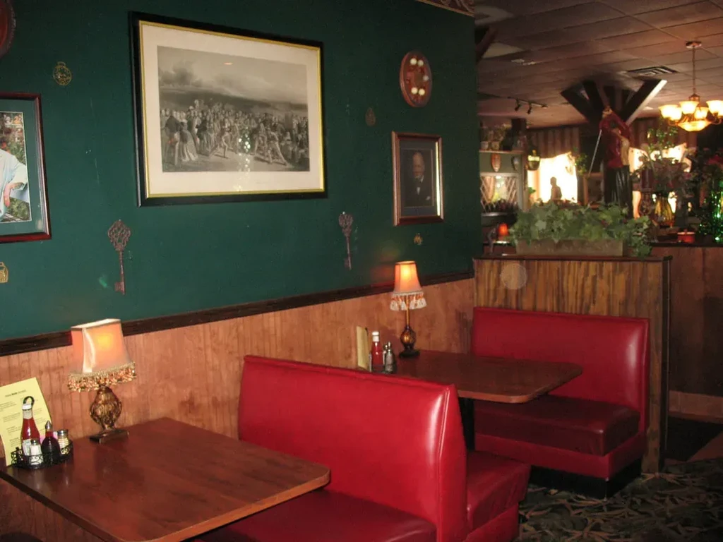 Vintage restaurant interior with red booths, green walls, and warm lamps.