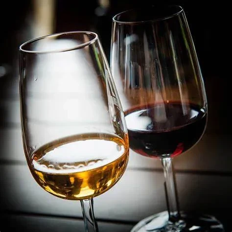 Two modern wine glasses, one with red wine, one with white wine.