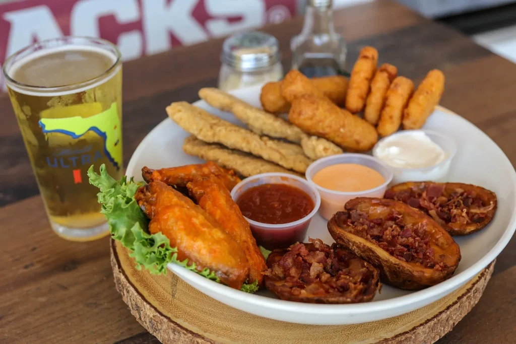 Close-up of fried appetizers, sauces, and a Michelob Ultra beer.