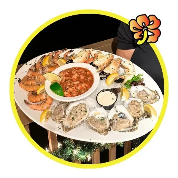 Large platter of fresh shrimp, crab, oysters, and ceviche on ice.