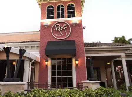 Roy's Hawaiian Fusion Cuisine restaurant facade, red tower, illuminated sign.