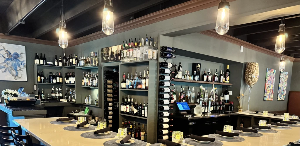 Sophisticated restaurant bar with extensive liquor display and warm lighting.