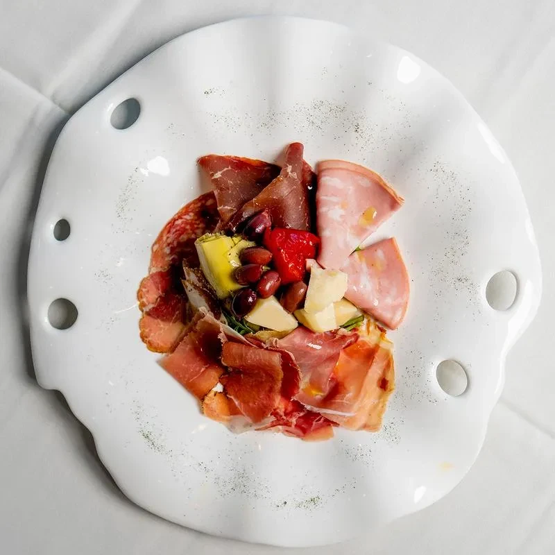 Artfully arranged antipasto platter with meats, cheeses, olives, and vegetables.