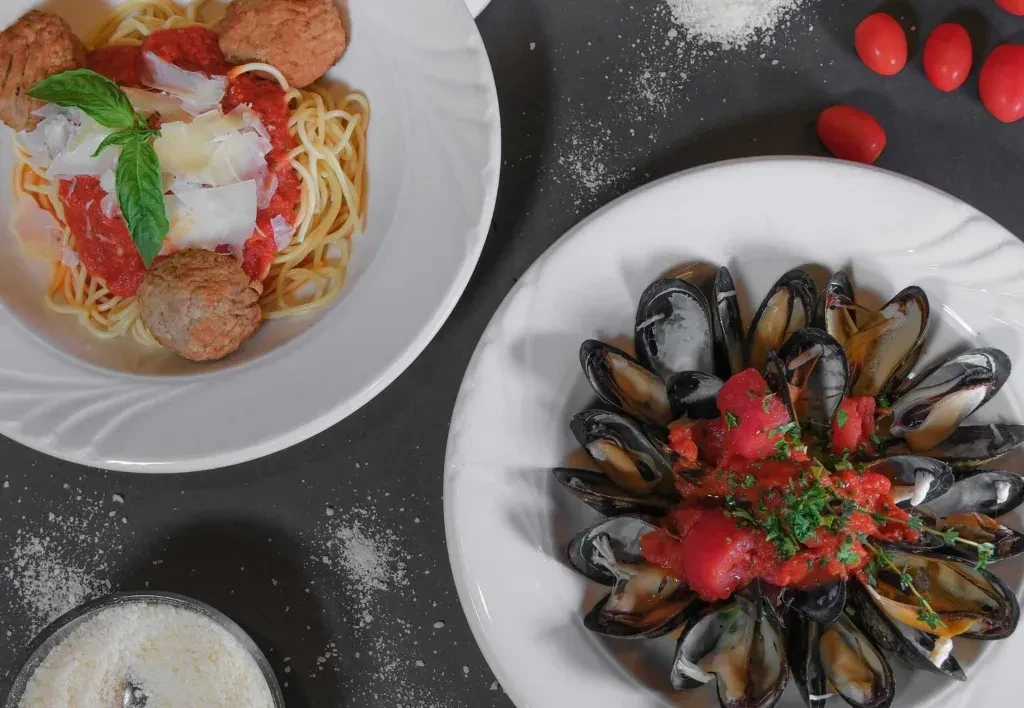 Spaghetti and meatballs, alongside mussels with tomato sauce.