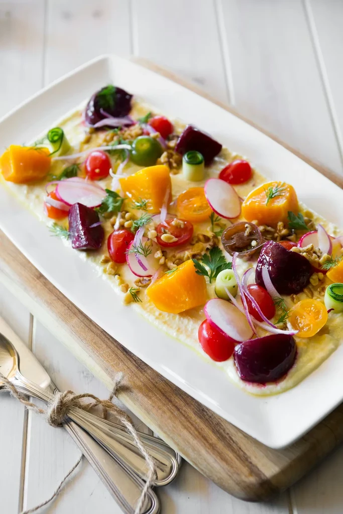 Vibrant root vegetable and fresh herb salad on a creamy base.