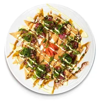 Plate of tuna poke nachos with wonton chips, sauces, and pickled ginger.