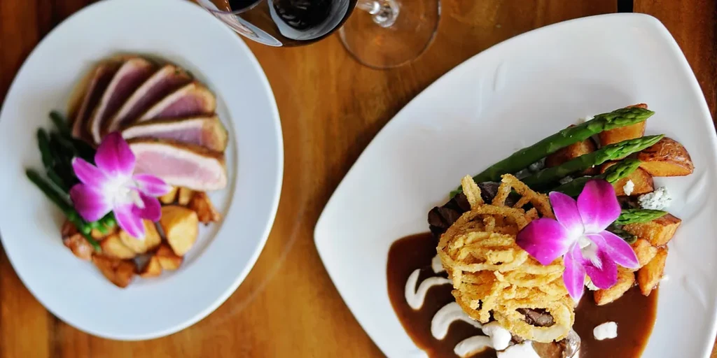 Two elegant plated dishes: seared meat, steak, asparagus, and wine.