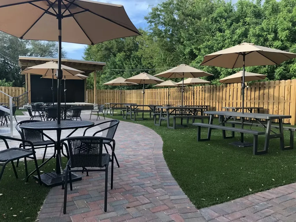 Spacious, empty outdoor dining area with diverse tables and umbrellas.