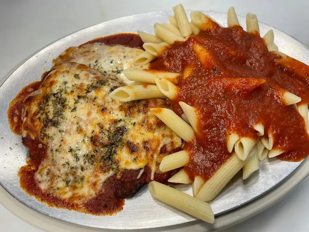 Breaded cutlet parmesan with penne pasta and marinara.