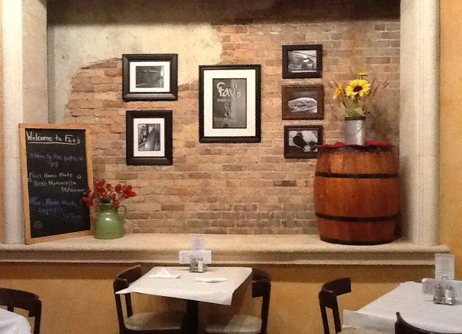 Rustic restaurant interior with brick wall, Fav's menu, and floral decor.