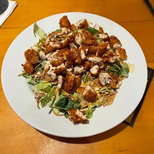 Prepared fried chicken salad with crispy noodles, almonds, and greens.