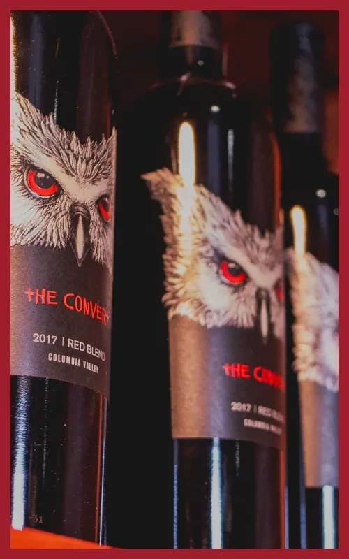 Three dark wine bottles with red-eyed owl labels and 'THE CONVENT'.