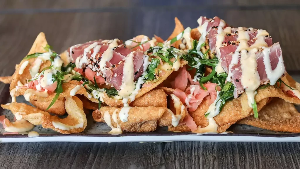 Seared tuna on crispy wonton chips with sauce, sesame, and ginger.
