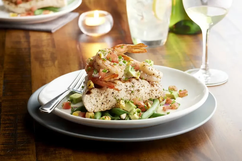Grilled fish with shrimp, avocado salsa, and green beans.