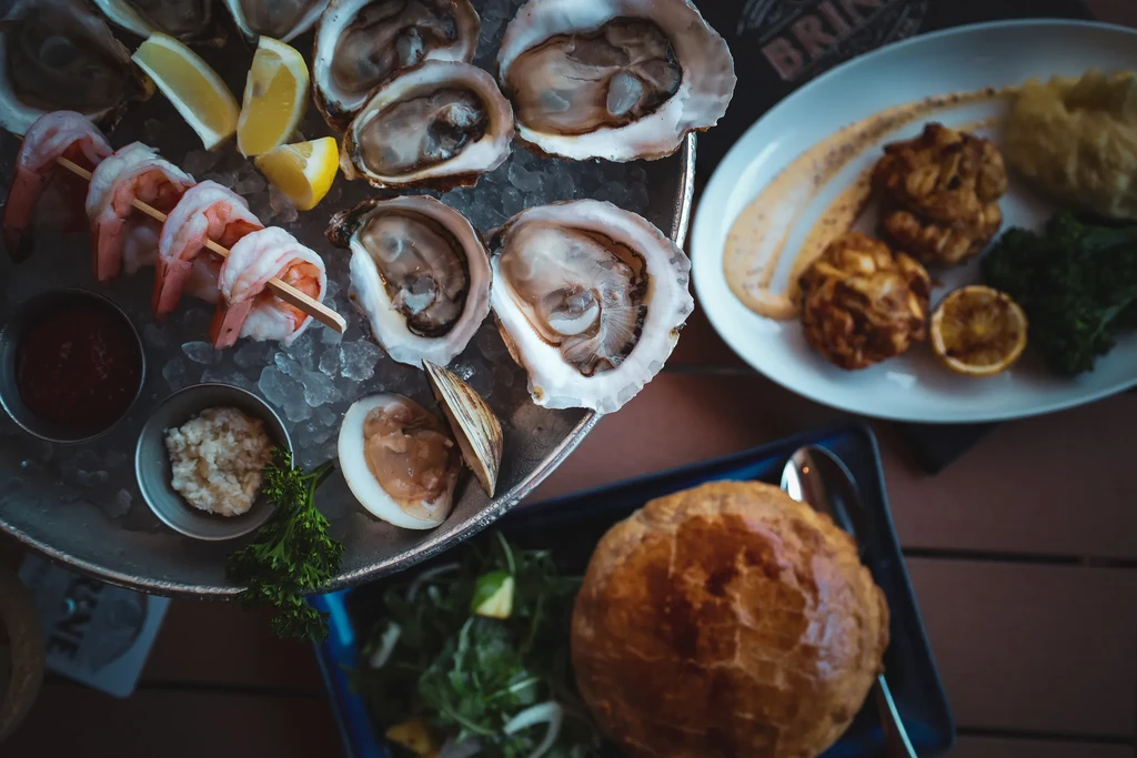 Overhead view of a seafood platter, fried fritters, and a pot pie.
