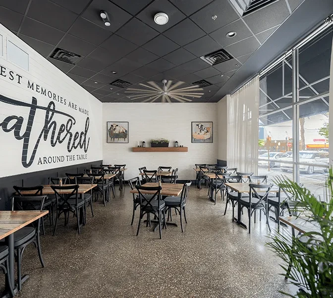Modern farmhouse restaurant dining area with wooden tables and chairs.