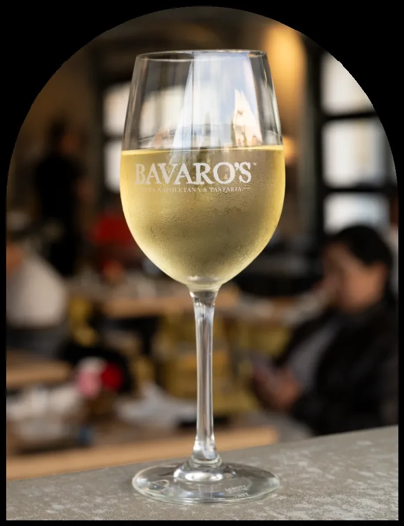 Chilled wine glass etched with BAVARO'S logo at a restaurant.