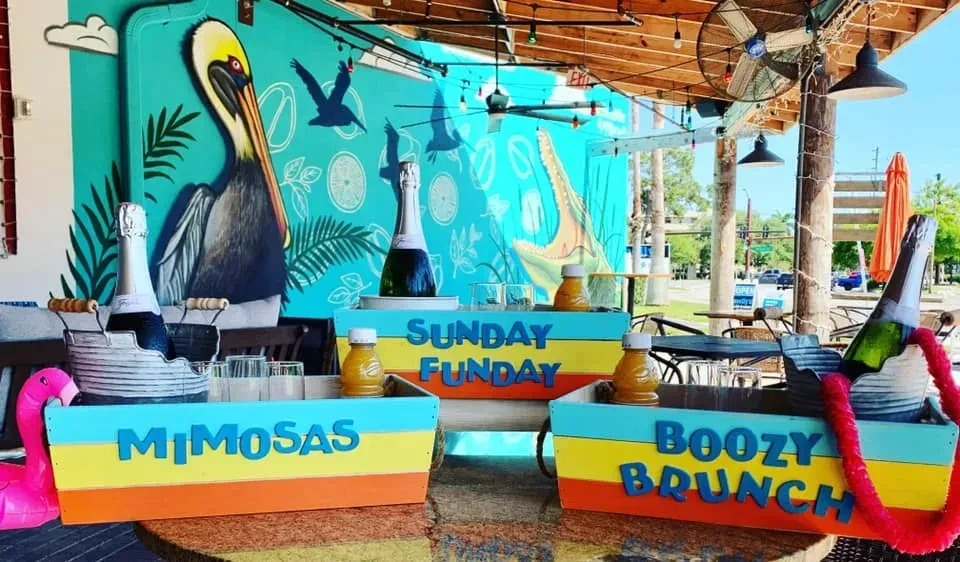 Three caddies with mimosa supplies on a bright, tropical-themed patio.