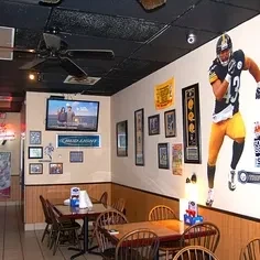 Dining area of a casual Pittsburgh Steelers-themed restaurant with sports decor.