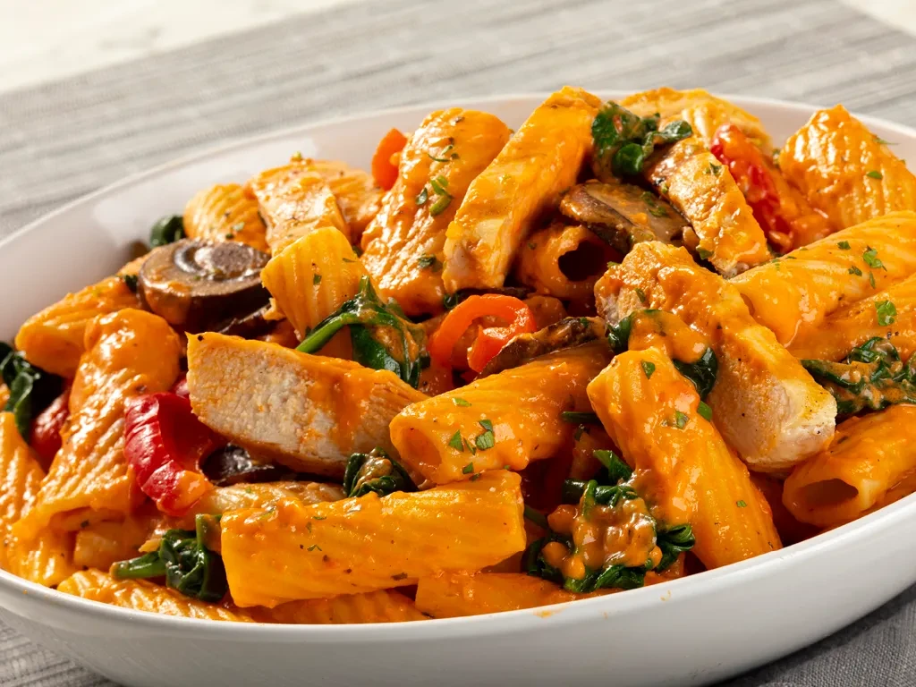 Rigatoni pasta with chicken, mushrooms, spinach, bell peppers in creamy sauce.