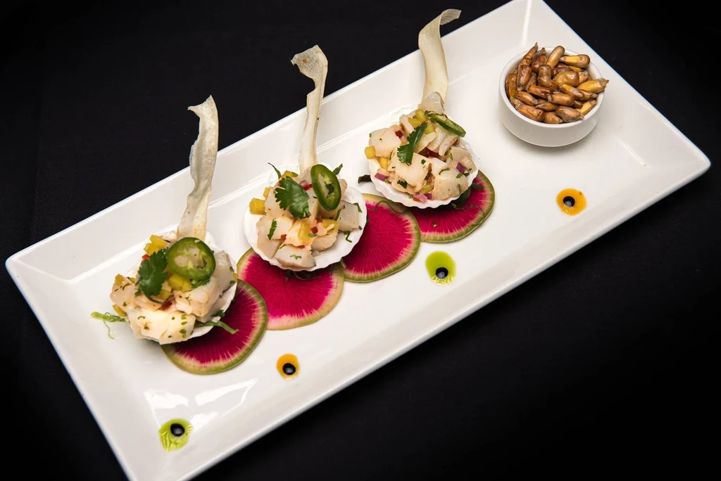Ceviche in scallop shells on watermelon radish, with toasted corn.