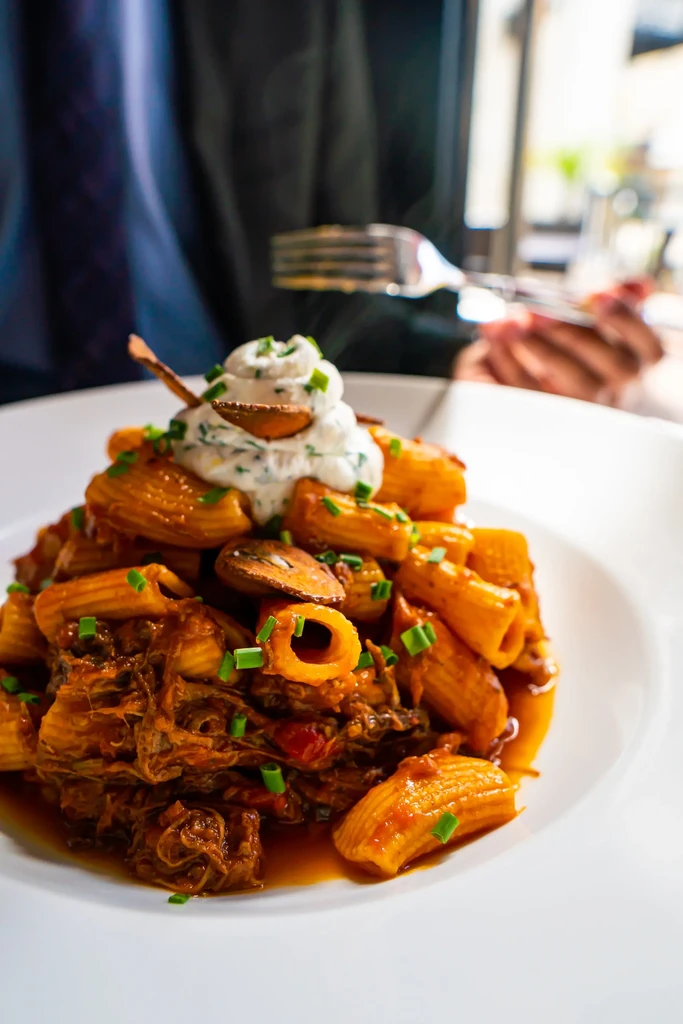 Rigatoni pasta with meat ragu, mushrooms, creamy sauce, and chives.