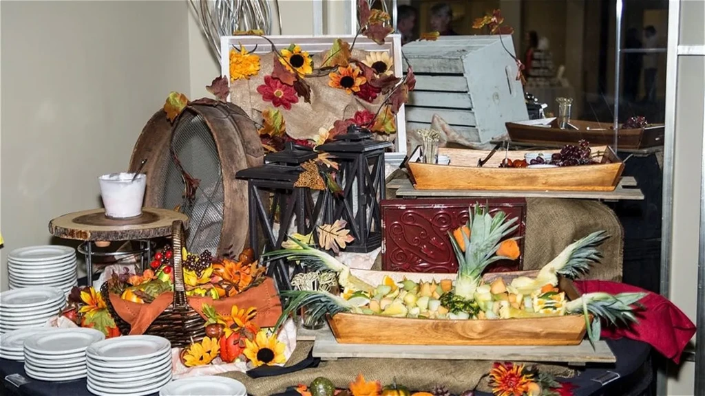 Vibrant autumn buffet table with fruit salads and festive fall decorations.