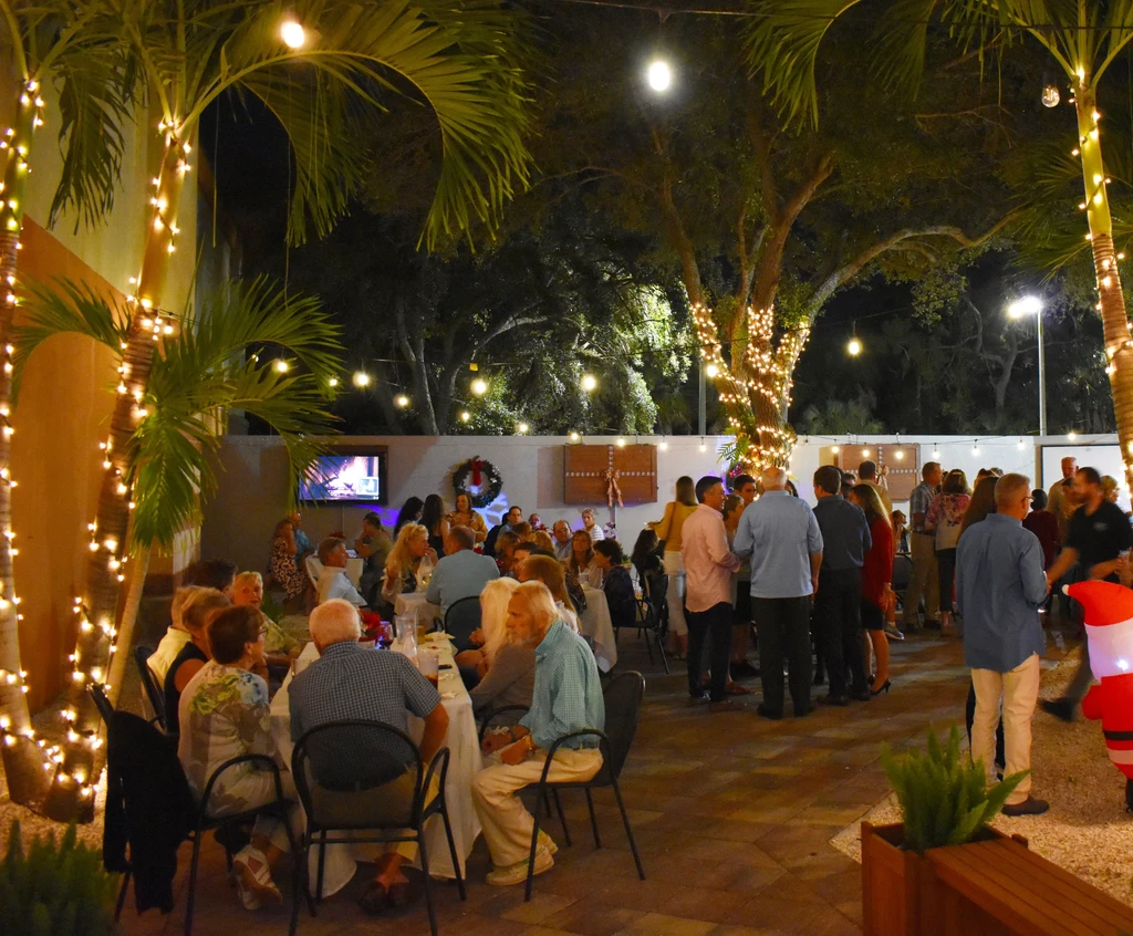 Lively outdoor evening event with string lights and holiday decorations.