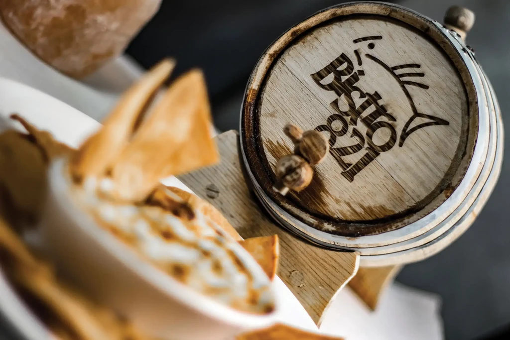 Creamy dip, chips, and a Bistro 821 wooden barrel with spigot.