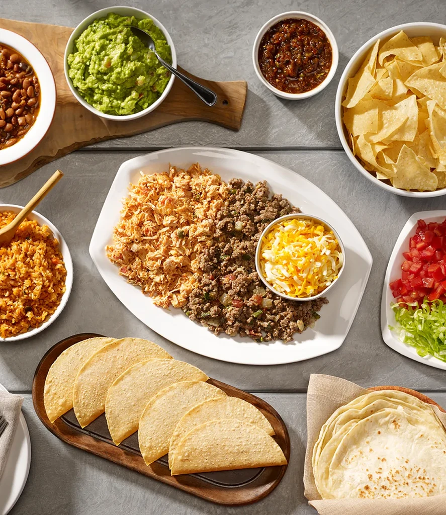 Vibrant overhead spread of Mexican food, including meats, cheese, and sides.