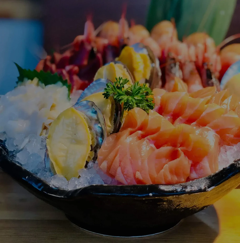 Fresh salmon sashimi, abalone, and prawns served on crushed ice.