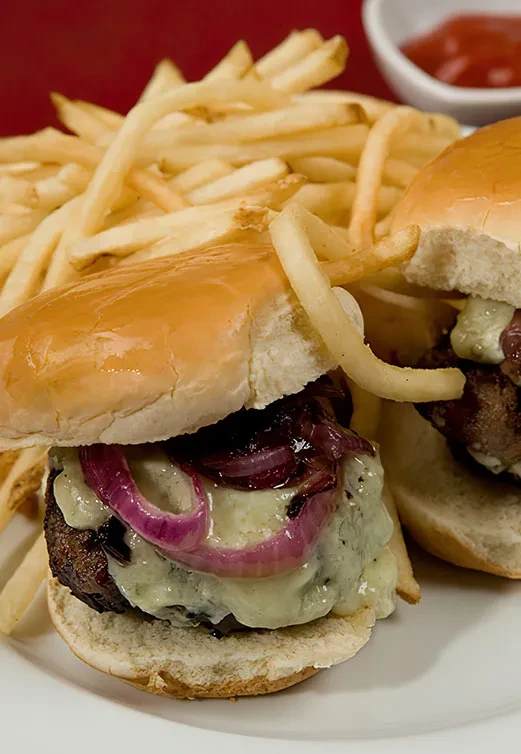 Two sliders with blue cheese, caramelized onions, and french fries.